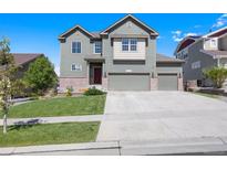 Charming two-story home with a well-maintained lawn and a three-car garage at 12210 Pine Post Dr, Parker, CO 80138