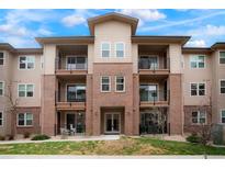 Inviting three-story condo building featuring brick accents and private balconies for outdoor enjoyment at 15345 W 64Th Ln # 107, Arvada, CO 80007