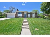 Inviting home showcasing a well-manicured lawn and a charming walkway to the front door at 1733 S Urban Way, Lakewood, CO 80228