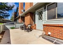 Charming front porch with two chairs and a brick accent wall offers a warm welcome at 3049 E Long S Cir, Centennial, CO 80122