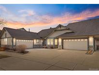 Beautiful single story home featuring a large driveway and attached garages at dusk at 23753 E Kettle Pl, Aurora, CO 80016
