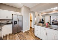 Bright kitchen with stainless steel appliances, granite countertops, and hardwood flooring, offering a modern and functional space at 246 Ash St, Bennett, CO 80102