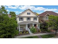 Charming two-story home featuring a welcoming front porch and beautiful landscaping at 2334 Yosemite St, Denver, CO 80238