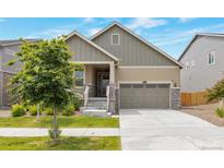 Charming two-story home with a well-manicured front yard, a covered porch and a two car garage at 24314 E Ford Ave, Aurora, CO 80018