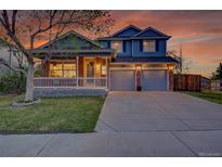 Charming two-story home featuring a covered porch and a two-car garage with a long driveway at 5457 S Valdai St, Aurora, CO 80015