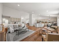 Bright living space with hardwood floors, modern furnishings, and an open concept to the kitchen at 5554 S Ward Way, Littleton, CO 80127