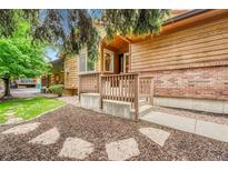 View of the home exterior with wooden and brick accents, complimented by a charming entrance at 11820 W 66Th Pl # C, Arvada, CO 80004