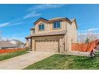 Charming two-story home features a two-car garage, fenced yard, and well-manicured lawn on a sunny day at 11020 Glacier Park Cir, Parker, CO 80138