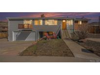 Charming home featuring a split-level design, garage, and quaint front porch seating area at 16805 W 16Th Pl, Golden, CO 80401