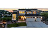 Beautiful two-story home with a well-manicured lawn and a two car garage at dusk at 423 Rogers Way, Castle Rock, CO 80104