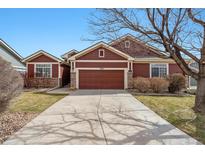 Charming single-Gathering home featuring a two-car garage, red siding and stone accents at 13756 Legend Trl # 101, Broomfield, CO 80023