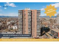 Multi-story condominium building with balcony views of the city skyline and mountain range under a bright blue sky at 130 N Pearl St # 1606, Denver, CO 80203