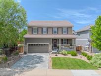 Charming two-story home with a well-manicured lawn, covered porch, and attached two-car garage at 7312 Grady Cir, Castle Rock, CO 80108