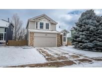 Charming two-story home featuring a brick facade and a two-car garage on a snow-covered lot at 10510 Berthoud Way, Parker, CO 80134