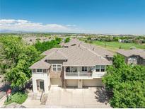 Well-maintained townhouse featuring a balcony, two-car garage, and manicured landscaping at 12912 Grant Cir # A, Thornton, CO 80241