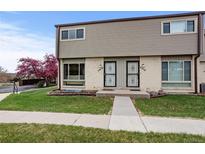 Charming townhome featuring a well-manicured lawn and lovely curb appeal with flowering tree at 4212 W Pondview Dr, Littleton, CO 80123