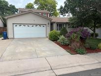 Charming home featuring a two-car garage, well-maintained lawn, and mature landscaping at 14963 E Adriatic Pl, Aurora, CO 80014