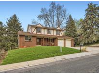 Charming two-story home featuring a brick facade, well-manicured lawn, and an attached two-car garage at 6768 Vivian St, Arvada, CO 80004