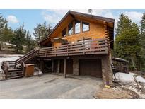 Charming log cabin featuring a spacious deck with outdoor seating and a two-car garage at 1673 Sinton Rd, Evergreen, CO 80439