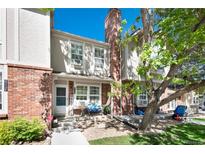 Charming townhome featuring brick accents, a cozy front porch, and a welcoming atmosphere at 9713 W Chatfield Ave # F, Littleton, CO 80128