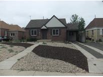 Charming brick home featuring a well maintained yard and driveway leading to a covered parking area at 3243 Albion St, Denver, CO 80207