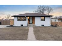 Charming single story home with a brick chimney, gray front door, and fresh black landscaping at 1632 S Quitman St, Denver, CO 80219