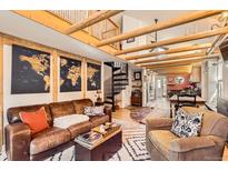 Inviting living room featuring exposed wood beams, a spiral staircase, and stylish decor in an open floor plan at 2314 Dexter St, Denver, CO 80207