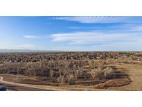 Expansive aerial view of a treed landscape, a city, and the blue sky with patterned clouds at 13393 E Asbury Dr # 103, Aurora, CO 80014
