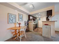 Charming kitchen with stainless steel appliances and a cozy dining area at 13393 E Asbury Dr # 103, Aurora, CO 80014