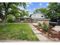 Charming two-story home featuring lush green lawn and landscaped front yard at 8935 W Swarthmore Dr, Littleton, CO 80123