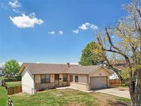 Charming one-story home with a well-maintained lawn and an attached one car garage at 831 Sable Blvd, Aurora, CO 80011