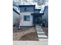 Contemporary two-story home with modern windows, light stone accents, and a landscaped front yard at 7360 Watercress Dr, Littleton, CO 80125