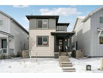 Charming two-story home with a welcoming entrance and snow-covered front yard at 7360 Watercress Dr, Littleton, CO 80125