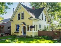 Charming yellow two-story home with a well-manicured lawn and inviting curb appeal at 310 Judson St, Longmont, CO 80501