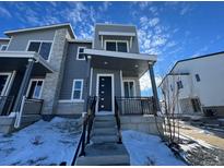 Modern two-story home with gray siding and stone accents, welcoming front porch, and steps leading to the entrance at 22841 E Stanford Ln # A, Aurora, CO 80015