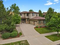 Spacious two-story home features a three car garage, manicured lawn and beautiful stone and wood accents at 24269 E Arapahoe Pl, Aurora, CO 80016