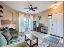 Cozy living room featuring a fireplace, ceiling fan and sliding doors to a balcony at 3230 Boulder Cir # 101, Broomfield, CO 80023