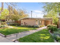 Charming mid-century home featuring a brick facade, mature trees, and a well-manicured lawn at 3242 4Th St, Boulder, CO 80304