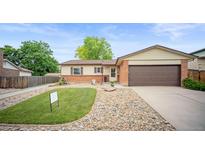 Charming ranch home with brick accents, a well-kept lawn, and an attached two-car garage at 7659 S Holland Way, Littleton, CO 80128