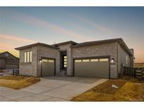 Stunning home with a stone facade, a two-car garage, and a well-maintained driveway at 7293 Canyon Sky Trl, Castle Pines, CO 80108