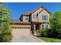 Charming two-story home featuring a well-manicured lawn and attached two car garage at 7081 S Oak Hill Cir, Aurora, CO 80016