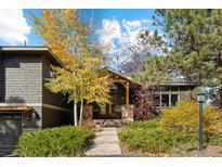 Gray shingled home with wood accents, stone steps, and landscaping at 166 S Rainbow Trl, Evergreen, CO 80439