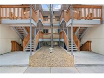 Exterior building view featuring walkways, multiple floors, and stone groundcover at 2835 S Monaco Pkwy # 1-103, Denver, CO 80222