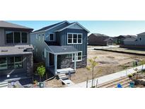 Charming two-story home features stone accents, gray siding, and a covered front porch at 20871 E 60Th Ave, Aurora, CO 80019