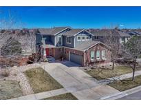 Beautiful two-story home featuring blue siding, brick accents, and well-maintained landscaping at 4812 S Fultondale Way, Aurora, CO 80016