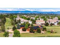 Expansive real estate with lush green lawns, mature trees, and mountain views on the horizon at 6191 S Olathe St, Centennial, CO 80016