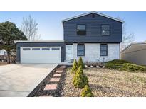Charming home featuring a two-car garage, inviting brick walkway, and manicured landscaping at 17233 E Princeton Dr, Aurora, CO 80013