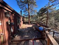 Large wooden deck with built-in benches and views of surrounding trees at 11130 Burland Dr, Golden, CO 80403