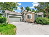 Charming home featuring stone accents, a well-manicured lawn, and an attached two-car garage at 7400 W Grant Ranch Blvd # 52, Littleton, CO 80123