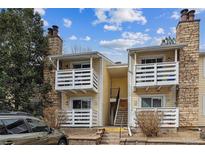 Charming condo exterior with balconies, stone accents, and yellow siding offering a cozy residential feel at 8555 Fairmount Dr # B202, Denver, CO 80247
